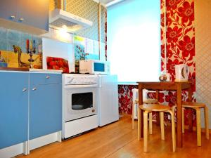 トゥーラにあるInndays on Krasnoarmeiskiy prospect 16のキッチン(青いキャビネット、テーブル、コンロ付)