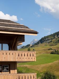 a wooden building with a view of a mountain at CGH Résidences & Spas Le Village De Lessy in Le Grand-Bornand