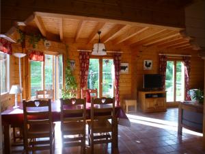 una sala da pranzo con tavolo e sedie in una cabina di Le Chalet de Philippe a La Bresse