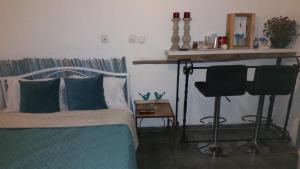 a bedroom with a bed and a desk and a chair at Kmo Yam In The Love Garden in Kinneret