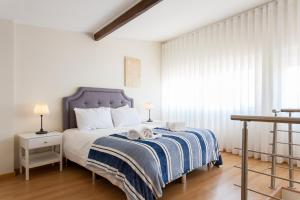 um quarto com uma cama com um cobertor azul e branco em JOIVY Bright 2BR Apt with River Views &balcony in Alfama, moments from Santa Apolonia train station em Lisboa
