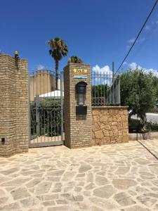 an entrance to a gate with a stone fence at B&B Tramonti d'aMare in Marsala