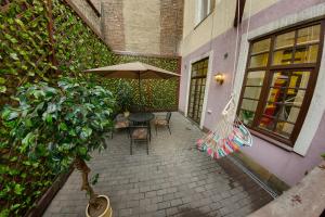 a patio with an umbrella and a table and chairs at Apartment City in Saint Petersburg