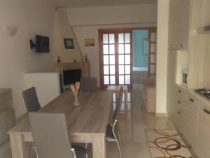 Holiday Rentals Taormina في تاورمينا: مطبخ وغرفة طعام مع طاولة وكراسي خشبية