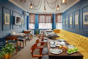 a restaurant with blue walls and tables and chairs at Easy Room in Nizhny Novgorod