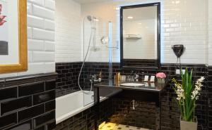 a black and white bathroom with a sink and a shower at Easy Room in Nizhny Novgorod