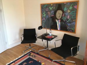 2 Stühle und ein Tisch in einem Zimmer mit einem Gemälde in der Unterkunft Nickhof B&B Resort in Inzigkofen