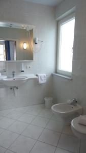 ein weißes Bad mit einem Waschbecken und einem WC in der Unterkunft Bad Kochenmoos in Naturns