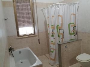 RilievoにあるAi capperi di siciliaのバスルーム(バスタブ、トイレ、シャワーカーテン付)