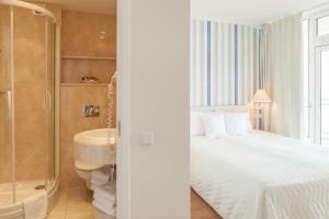 sypialnia z łóżkiem, prysznicem i umywalką w obiekcie Hotel Bryza Resort & Spa w Juracie