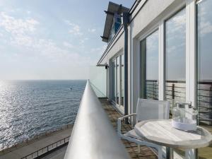 balcón con mesa, sillas y vistas al océano en atoll apartments, en Helgoland