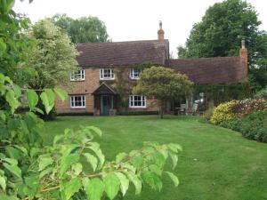 una vecchia casa in mattoni con un ampio cortile di Lime Trees Farm a Bicester