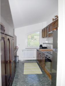 una cucina con pareti bianche, armadi in legno e una finestra di Apartment Zupan a Maribor