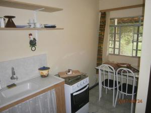 a kitchen with a sink and a stove at Kitnet Penedo in Penedo