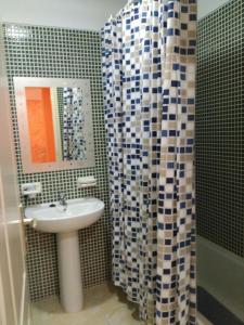 un bagno con lavandino e tenda da doccia di Apartamento Delgado y Ruiz a Puertito de Güímar