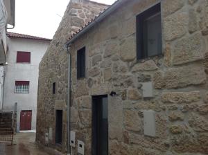 un edificio de piedra con ventanas laterales en Antiga Casa do Boi, en Viseu
