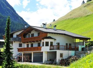 een huis in de bergen met een groene heuvel bij Bauernhof Entalhof in Finkenberg