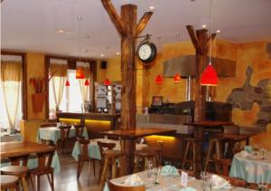 a restaurant with tables and chairs and a clock on the wall at La Table Alsacienne in Farébersviller