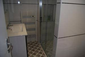 a bathroom with a glass shower and a sink at Ramier in Giverny