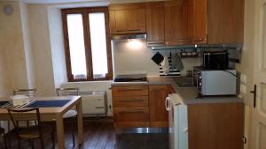 a kitchen with wooden cabinets and a table in it at casa del cirillo in Ornica