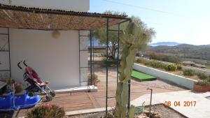 una mujer en un cochecito sentada en una cubierta de madera en Holiday Homes en Porto San Paolo