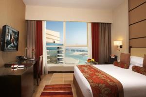 a hotel room with a large bed and a large window at Khalidiya Palace Rayhaan by Rotana, Abu Dhabi in Abu Dhabi