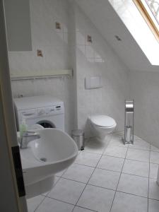 Baño blanco con lavabo y aseo en Ferienwohnung Ostseenähe, en Hirschburg