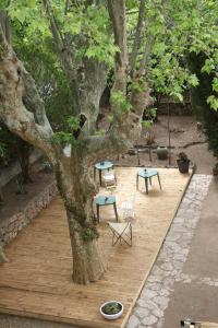 サン・ラファエルにあるル プラド ドゥ サン ラフの木の下にテーブルと椅子が置かれた木製デッキ