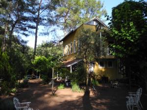 a yellow house with white chairs in front of it at Daphne House in Olympos