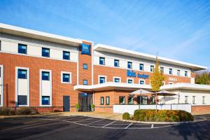 a us hotel with a parking lot in front of it at ibis budget Leicester in Leicester