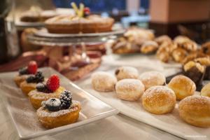
a variety of pastries are displayed on a table at Hotel La Pace in Pisa
