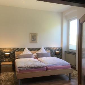 een slaapkamer met een bed met kussens erop bij Haus Mosella in Cochem