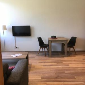 een woonkamer met een tafel en een televisie aan de muur bij Haus Mosella in Cochem