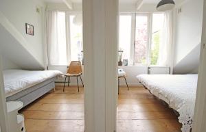 ein Schlafzimmer mit 2 Betten und einem Tisch im Fenster in der Unterkunft Beautiful 2 floor Vondelpark apartment. in Amsterdam
