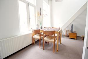 ein Esszimmer mit einem Tisch, Stühlen und Fenstern in der Unterkunft Beautiful 2 floor Vondelpark apartment. in Amsterdam