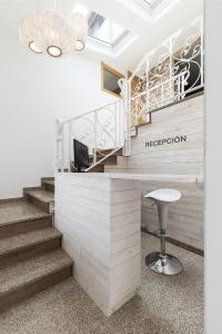 a reception desk in a lobby with stairs at Pension Residencial Victoria in Santa Cruz de Ribadulla