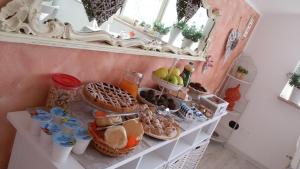 una mesa con un estante con comida y un espejo en B&B A casa di Eleonora en Villafranca di Verona