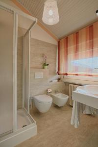a bathroom with a shower and a tub and a sink at Hotel Europa - Sorico in Sorico