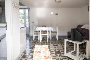 a kitchen and dining room with a table and a tv at Salvatore 6 in Ponza +7 photos