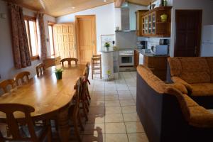 a kitchen and dining room with a wooden table and chairs at La Parcela in Riumar