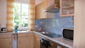 a kitchen with wooden cabinets and a sink and a window at Apartment Rudi in Garmisch-Partenkirchen