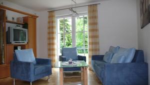 a living room with two blue chairs and a table at Apartment Rudi in Garmisch-Partenkirchen