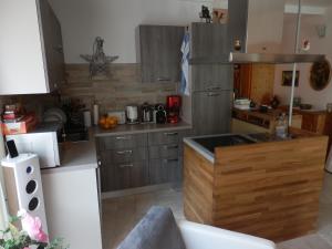 una cocina con armarios de madera y fregadero. en Luxeriöses Apartment 52 ViraLago, en Vira