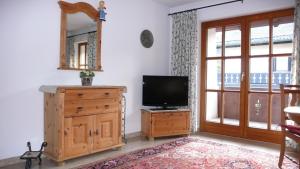 a living room with a television and a wooden dresser at Apartment Jasmin in Garmisch-Partenkirchen
