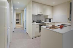 a kitchen with white cabinets and a counter top at Bravissimo Cort Reial-2A in Girona
