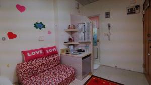 a small room with a red couch and a shower at Mei Di Ya House in Yuli
