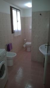 y baño con aseo y lavamanos. en Appartamento Villa Edera, en Baja Sardinia