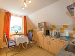 a kitchen with a table and a sink in it at Gaestehaus Heuer in Baabe