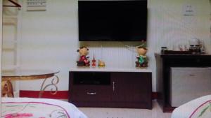 a living room with a flat screen tv on a wall at Mei Di Ya House in Yuli
