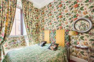 a bedroom with a bed with floral wallpaper at Casa Heberart Guest House Sistina in Rome
